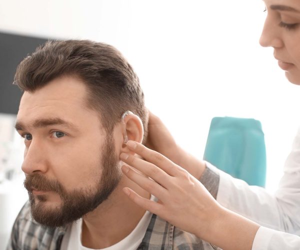 Audioprothésiste mettre prothèse auditive dans l'oreille de l'homme